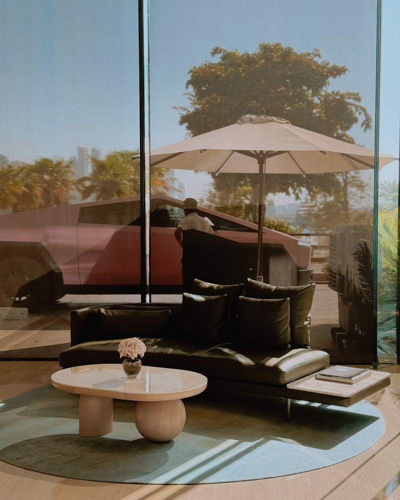 A hotel lobby corner with a dark leather sofa and a sculptural stone table in afternoon sun